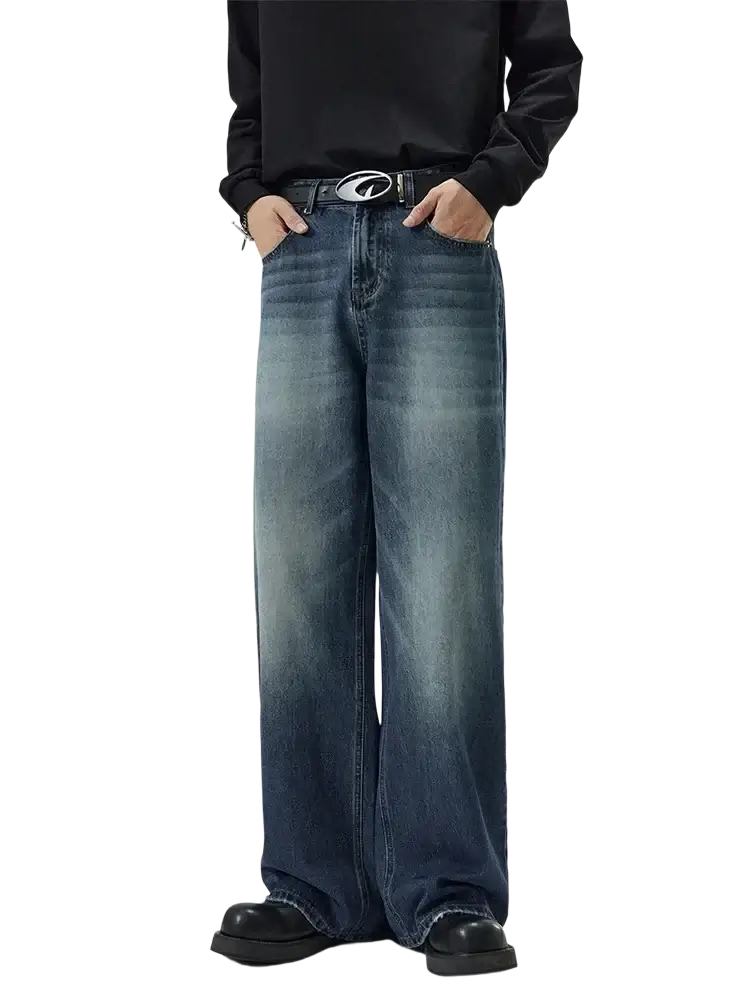 Distressed vintage baggy men denim jeans in faded blue wash with subtle whiskering and frayed hems
