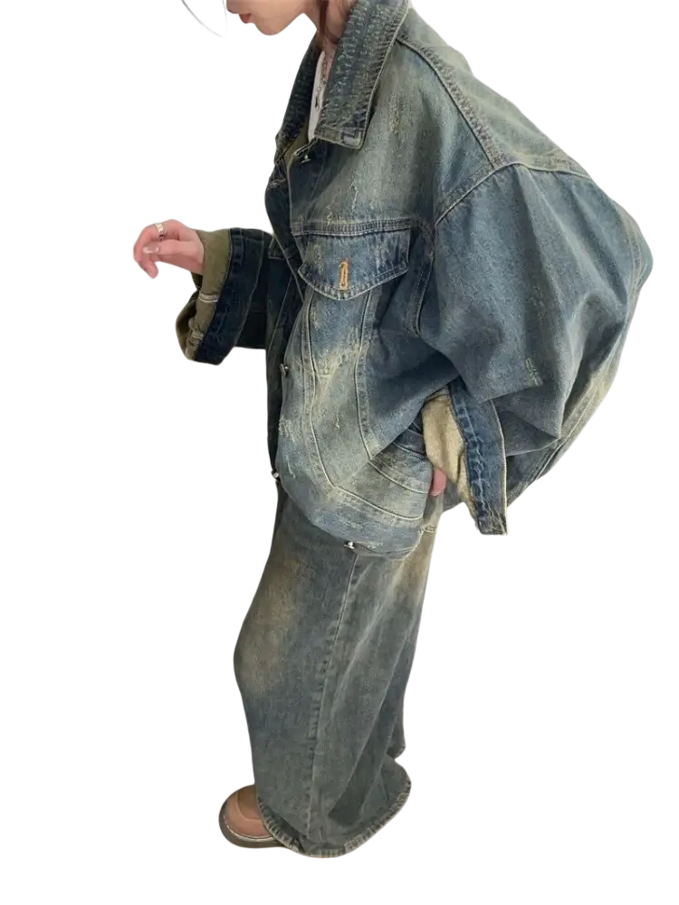 A faded blue distressed vintage denim jacket with a relaxed oversized fit and visible stitching details