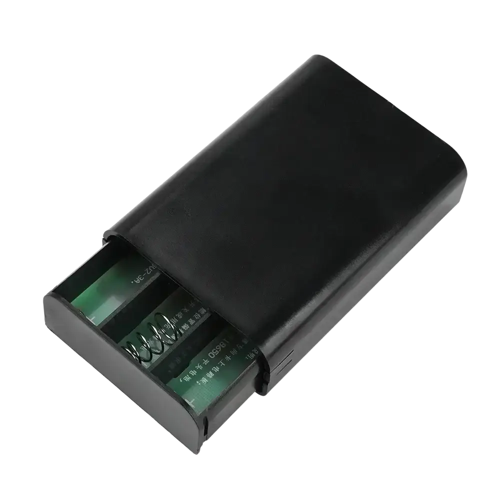 Black plastic diy 18650 power bank shell holding two green aa batteries with visible spring contacts for internal charging current