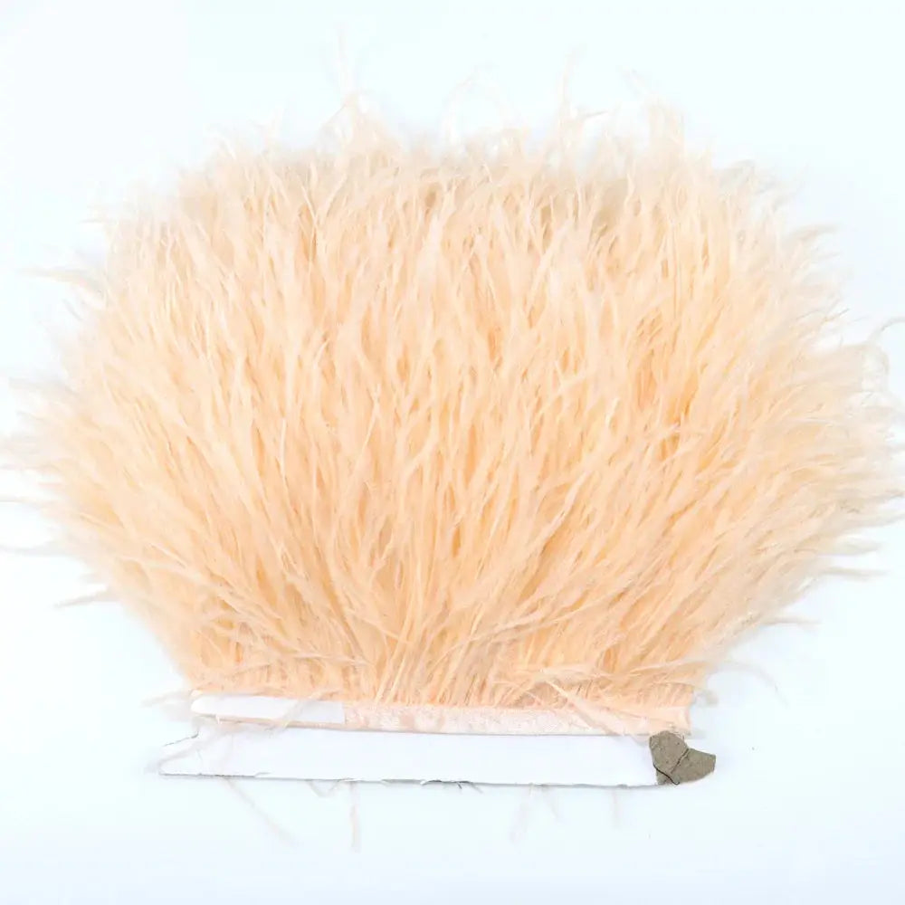 Premium feather fringe and ostrich trim with fluffy peach-colored long soft strands and slightly frayed edges for diy fashion