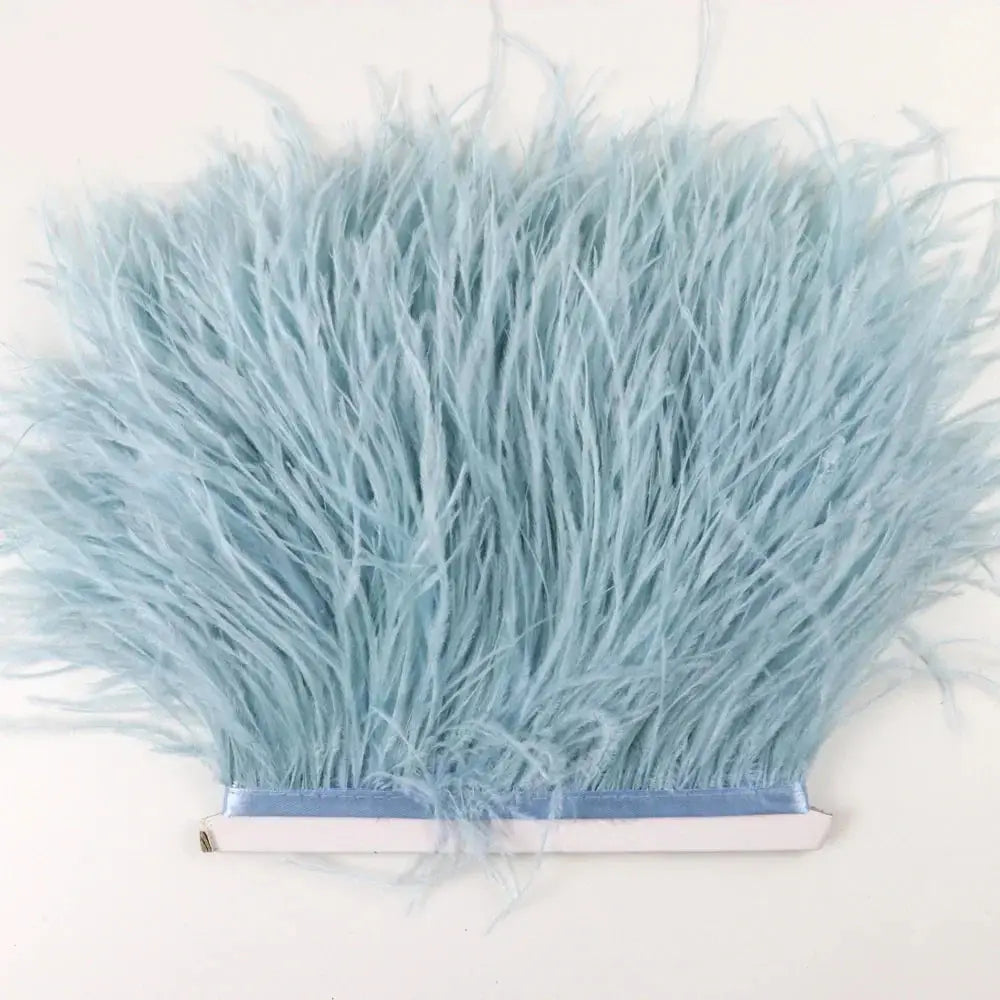Light blue ostrich feather trim with soft fluffy texture neatly attached to white adhesive backing for diy fashion