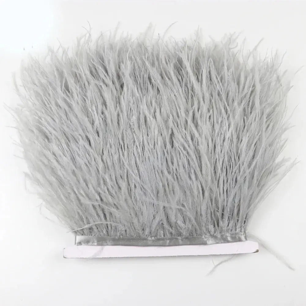 Gray synthetic feather trim with dense fluffy texture and white adhesive backing for diy fashion projects