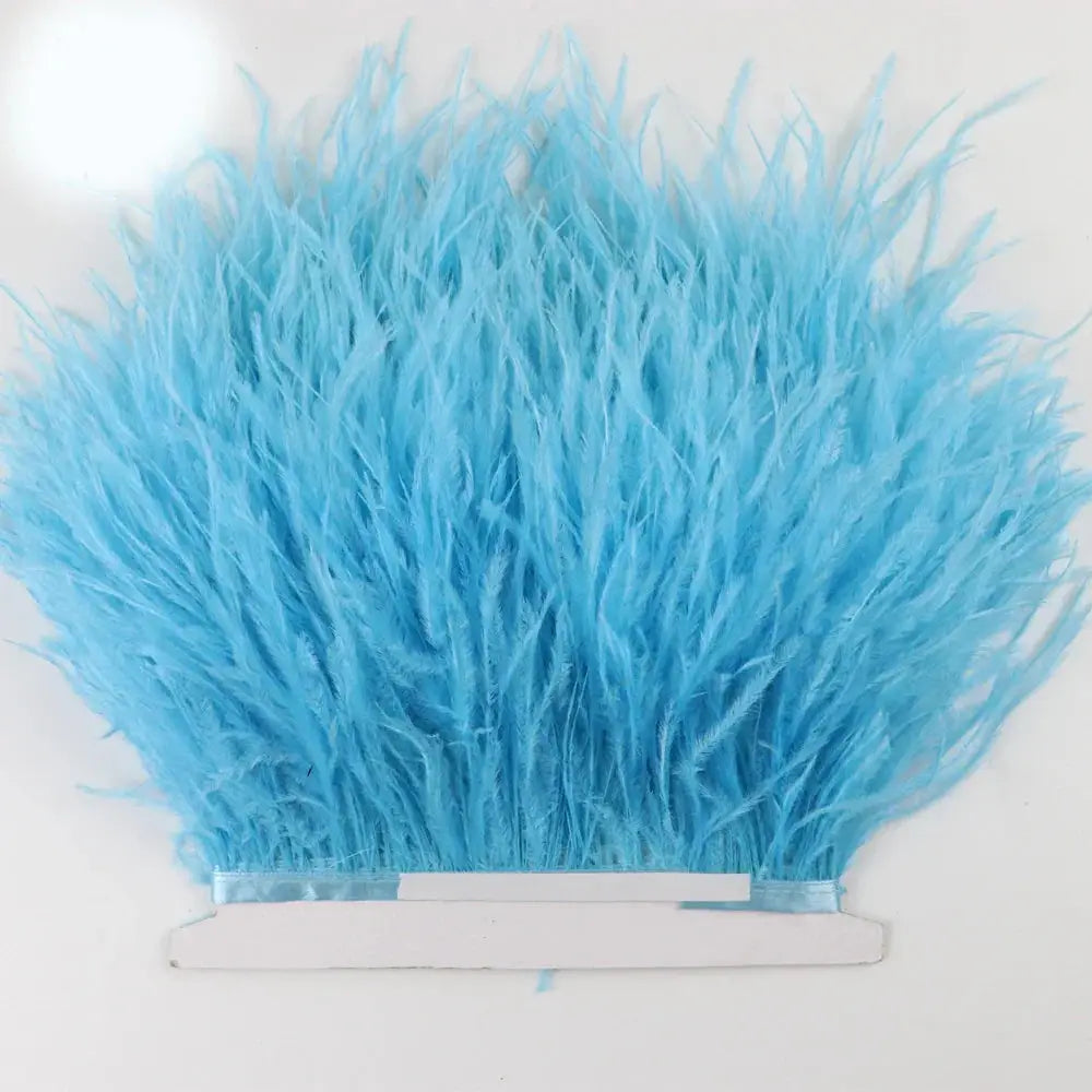 A vibrant sky blue premium feather fringe and ostrich trim with soft fluffy texture and white adhesive backing