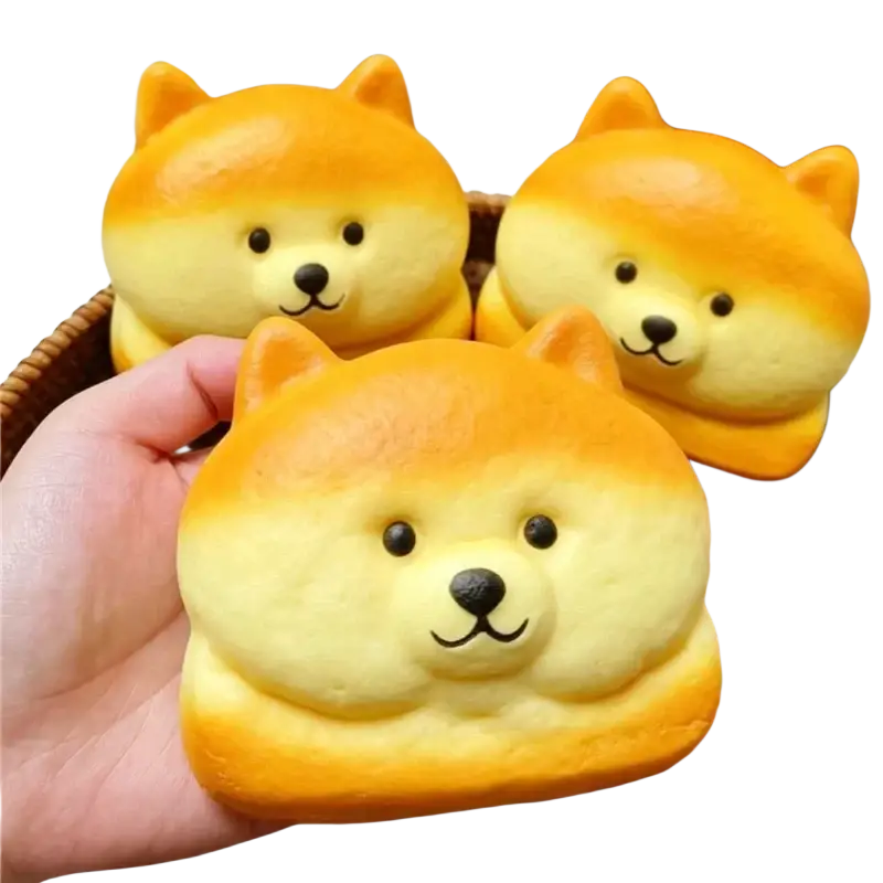 Golden and pale yellow silicone dog-shaped slow rising squishy toys with black eyes and stitched smiles