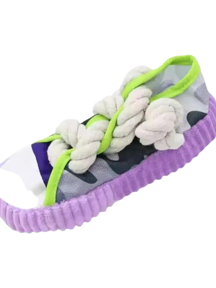 A playful dog chew toy featuring a camouflage sneaker design with lime green laces and purple corduroy trim