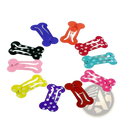 A set of colorful bone shaped metal dog hair clips with solid and polka dot shiny plastic surfaces