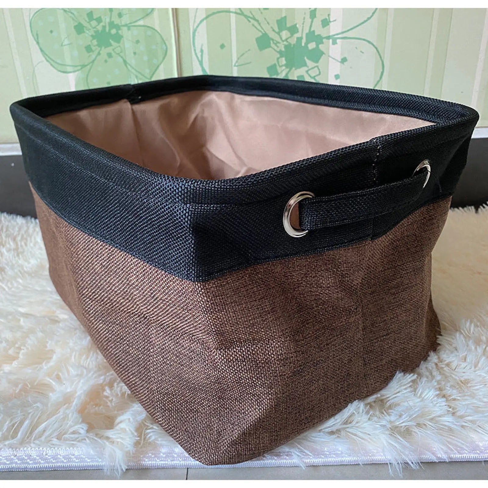 Brown and black fabric dog toy basket with woven texture, reinforced edges, and metal grommet handles for pet supplies storage
