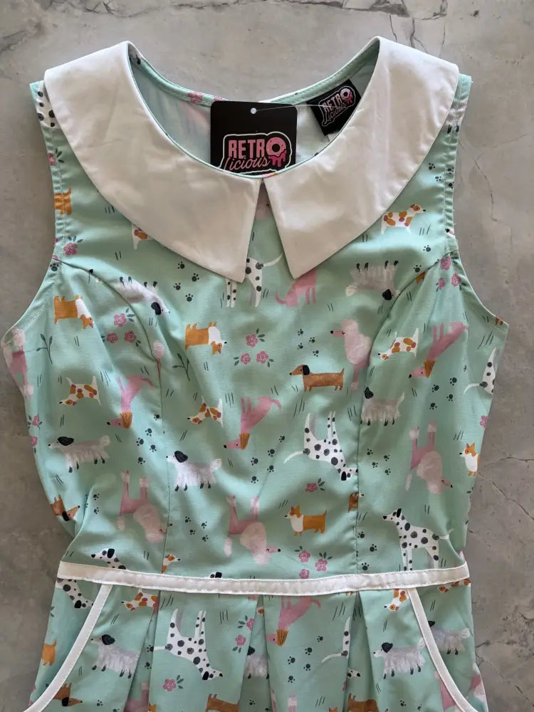 A mint green sleeveless cotton A-line dress with white peter pan collar and dachshund print with pockets