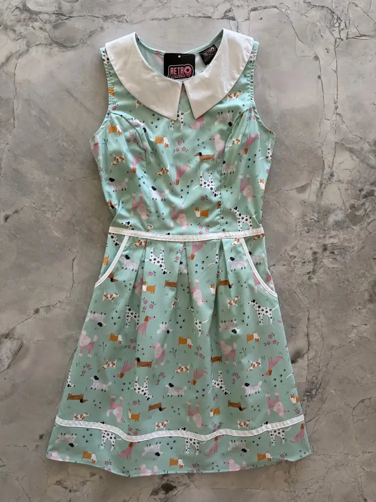 A mint green sleeveless retro a-line cotton dress with white peter pan collar and colorful dog print with pockets