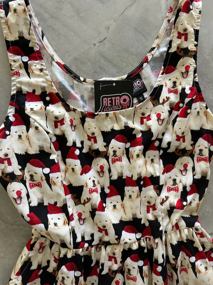 Black cotton fit and flare holiday dress with white puppies wearing red santa hats and bow ties pattern
