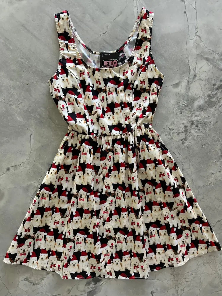 Black sleeveless cotton fit and flare holiday dress with white puppies wearing red santa hats and scarves pattern