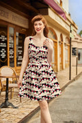 A sleeveless black and white cotton fit and flare dress with cartoon poodles wearing red santa hats holiday design