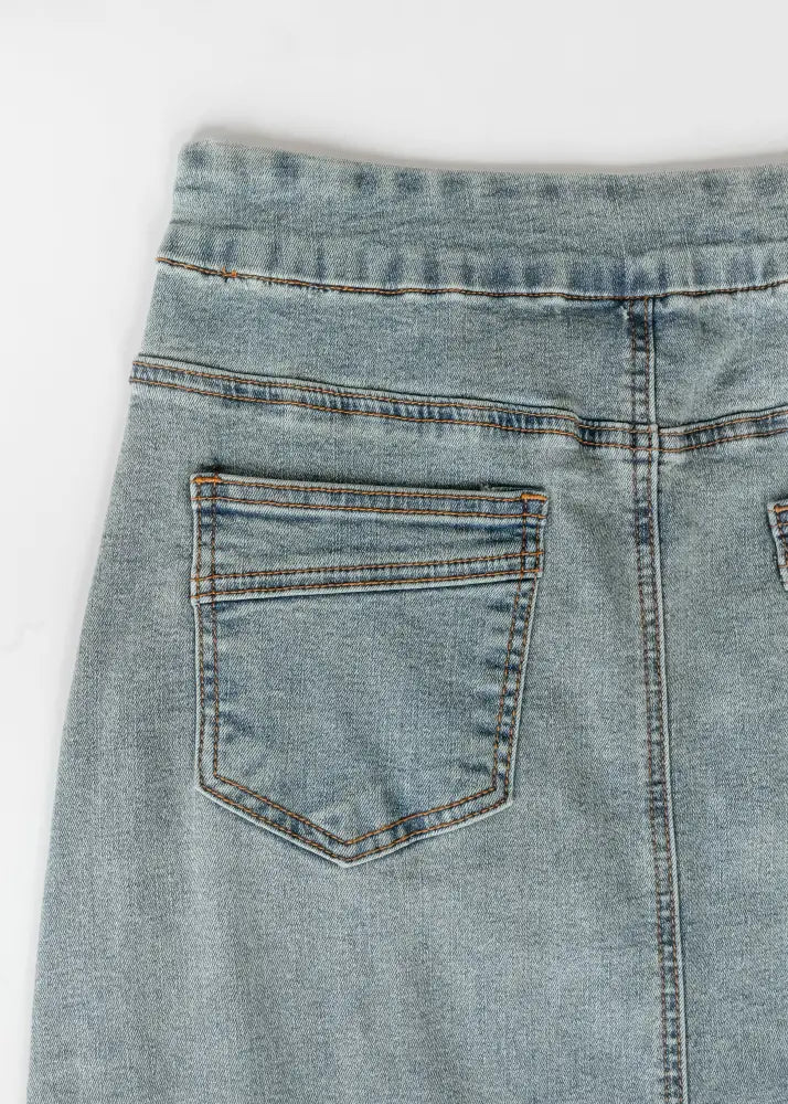Back side of donna classic wash stretch denim maxi skirt in light wash with classic back pocket and contrasting stitching