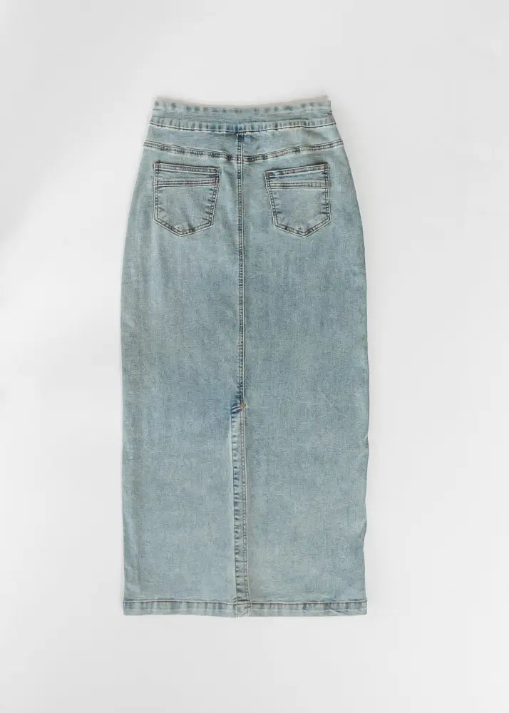 Back view of donna classic wash stretch denim maxi skirt in light wash with two back pockets and central seam