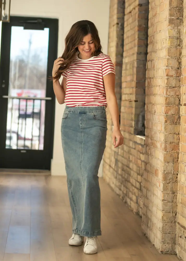 A woman wearing a red and white striped top with a light-wash stretch denim maxi skirt with pockets by Donna