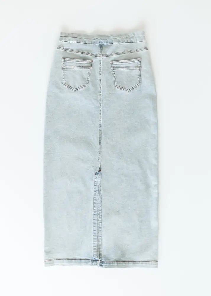 Donna light wash stretch denim midi skirt with straight cut, back pockets, and central front seam shown from the back