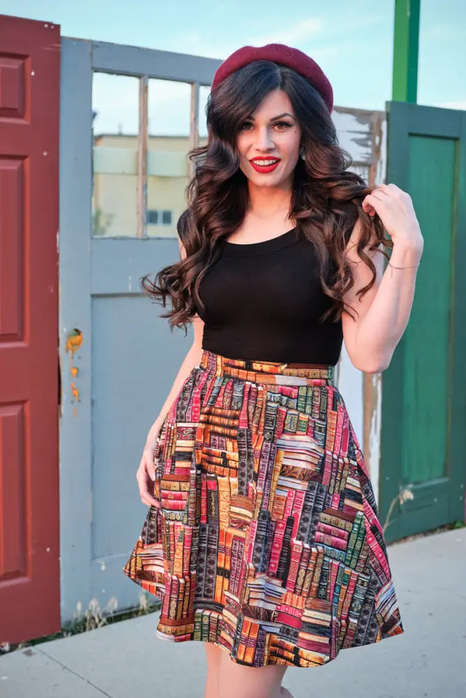 A vibrant cotton a-line skirt with pockets featuring a colorful vintage book print in various hues and sizes