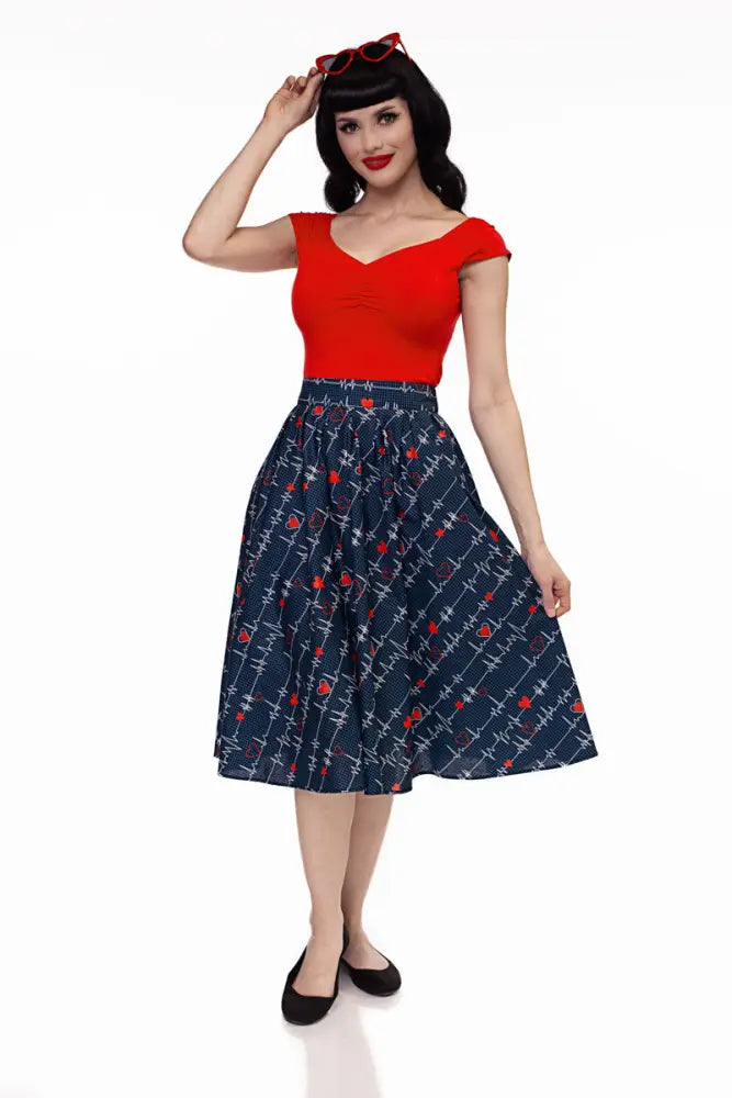 A navy blue vintage pleated Doris heartbreaker skirt with white barbed wire and red rose pattern paired with red top