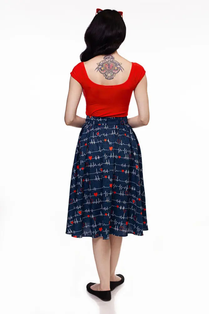Navy blue pleated midi skirt with white heartbeat lines red hearts and pockets styled with a red top