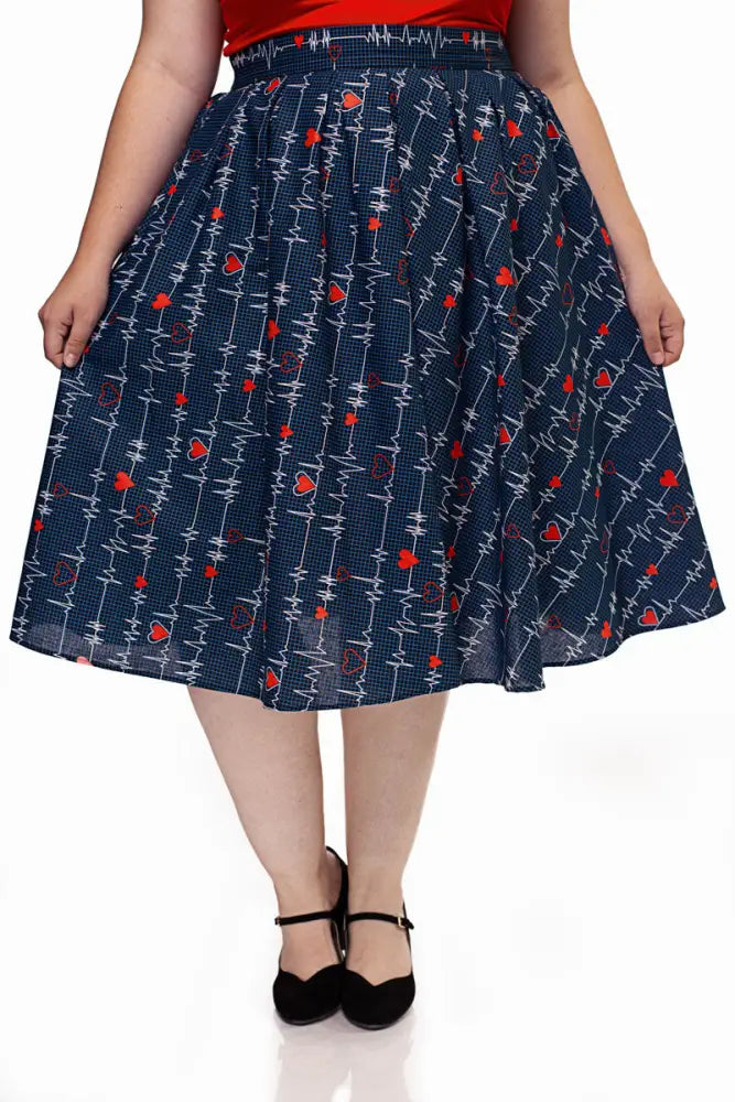 A navy blue a-line Doris navy pleated heartbreaker skirt with red heart and white electrocardiogram pattern on textured fabric