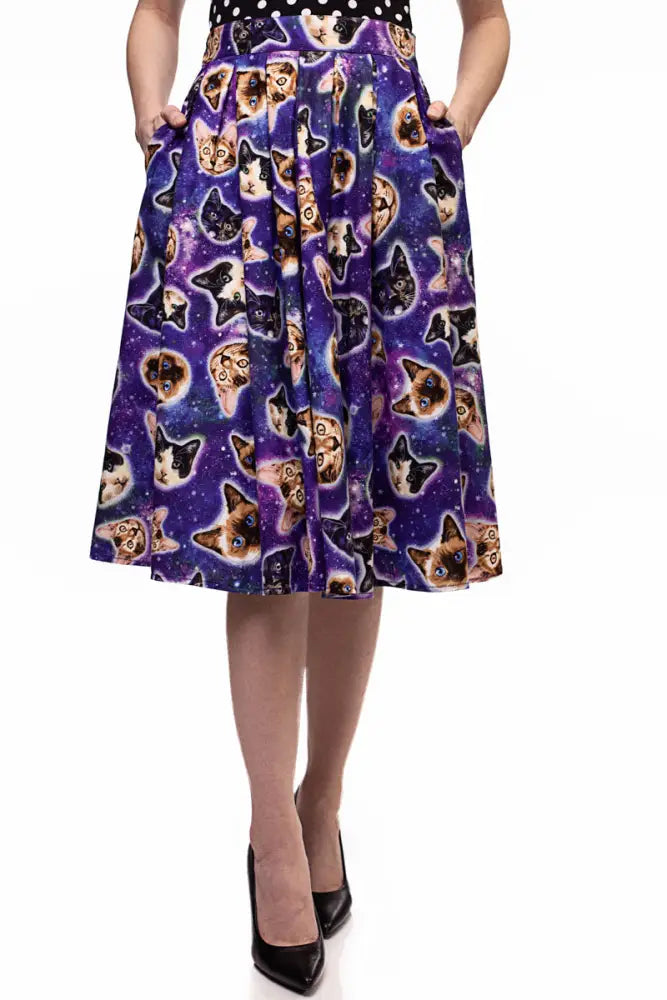 Purple pleated a line skirt with vibrant cosmic pattern featuring repeating cat faces on a starry background