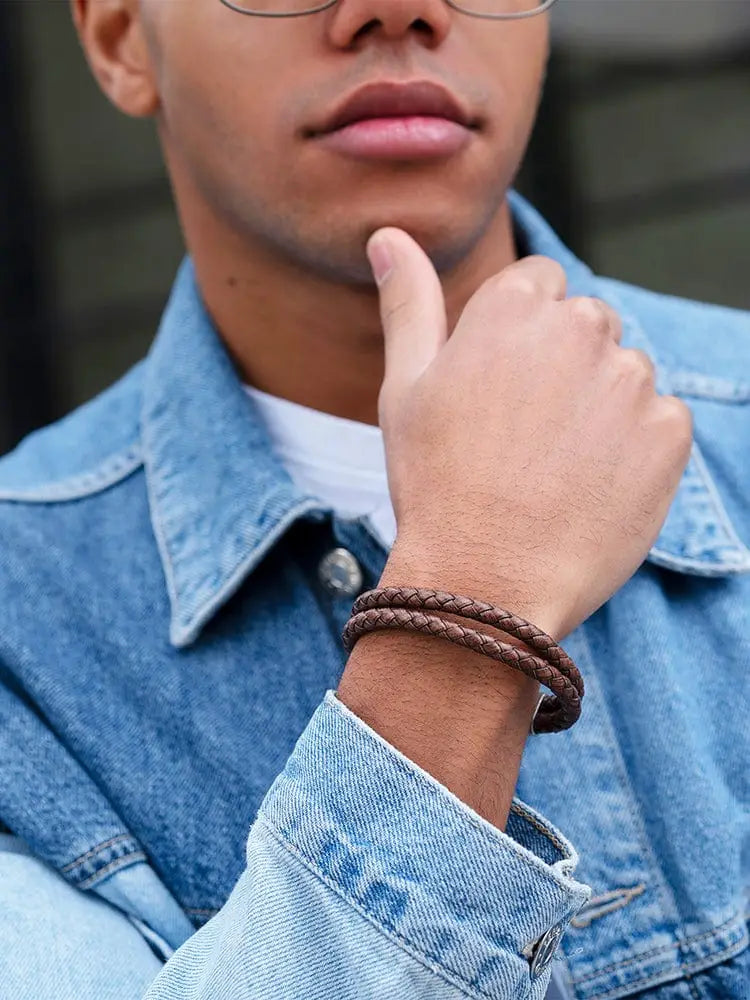 Double brown braided leather bracelet with stainless clasp worn on wrist showcasing detailed craftsmanship
