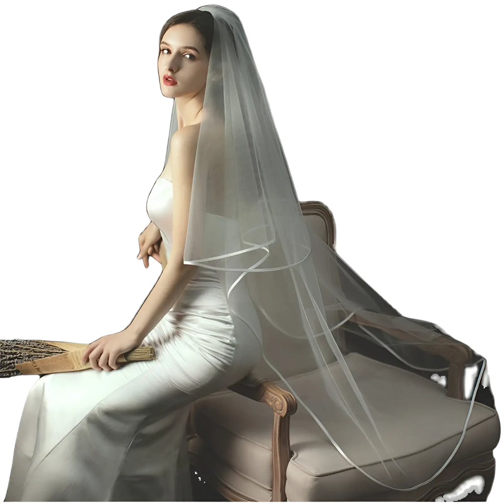 A delicate double layer white tulle short veil with hair comb drapes softly over the model’s head and shoulders