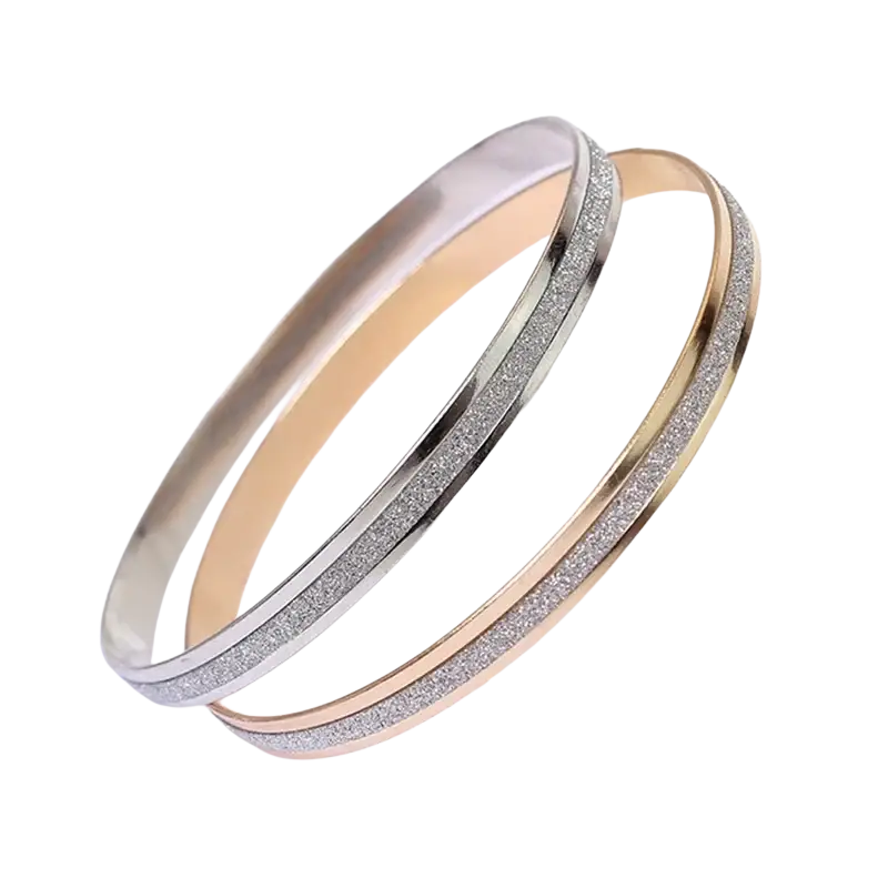 Two metallic double ring metal bangle bracelets in rose gold and silver with glittery silver edges on white surface