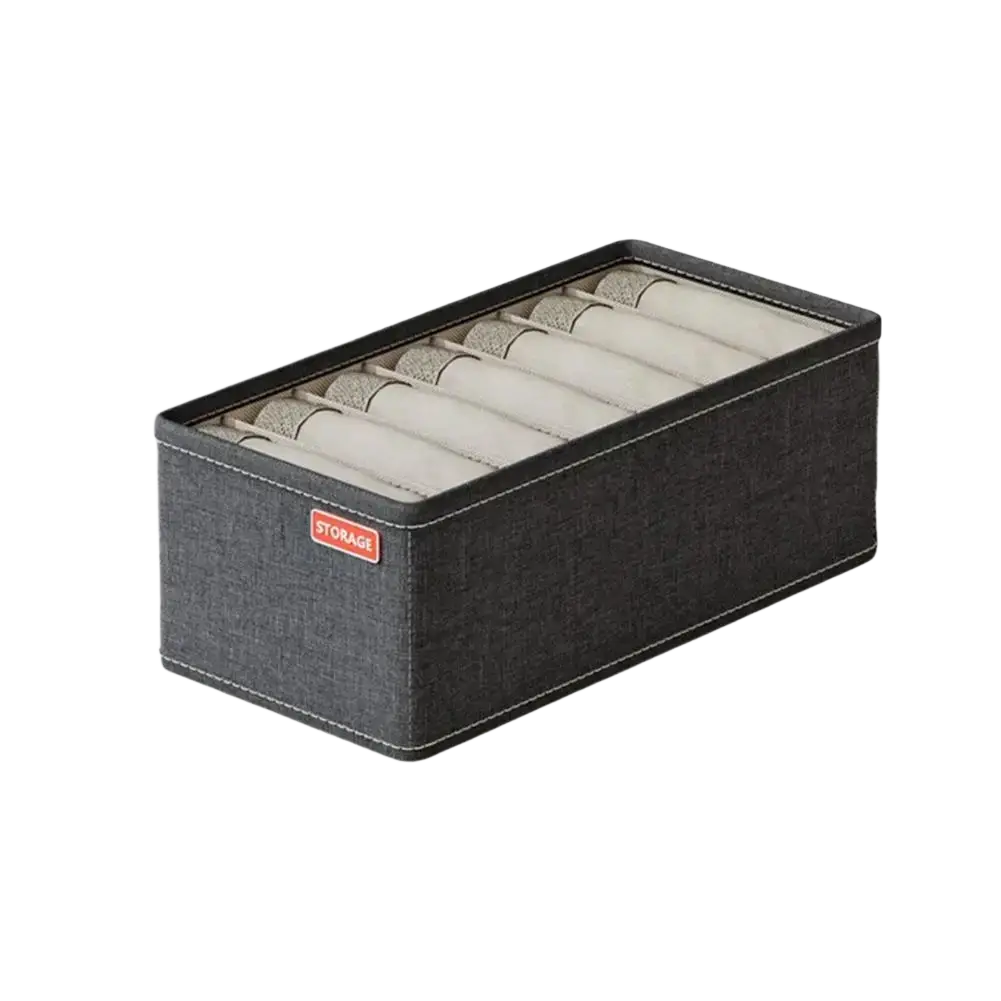 Black textured fabric drawer organizer box with beige interior compartments holding rolled underwear and socks