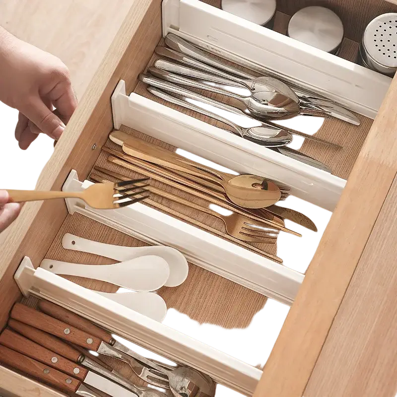 White plastic expandable drawer organizer with integrated slots for neatly separating and holding cutlery