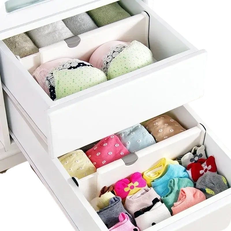 White plastic drawer partition organizer with adjustable compartments holding folded bras and socks for storage