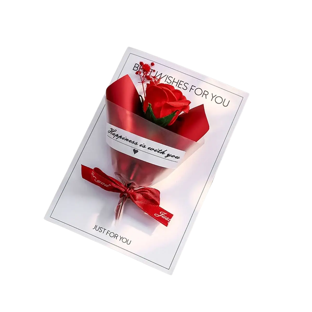 A vibrant red artificial rose wrapped in glossy paper with ribbon inside a white dried flower greeting card for best wishes