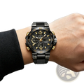 Black and gold dual display sports watch with digital-analog features and a black mesh bracelet