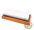 Wooden base holding a dual sided whetstone with white 1000 grit and brown 400 grit abrasive surfaces for sharpening