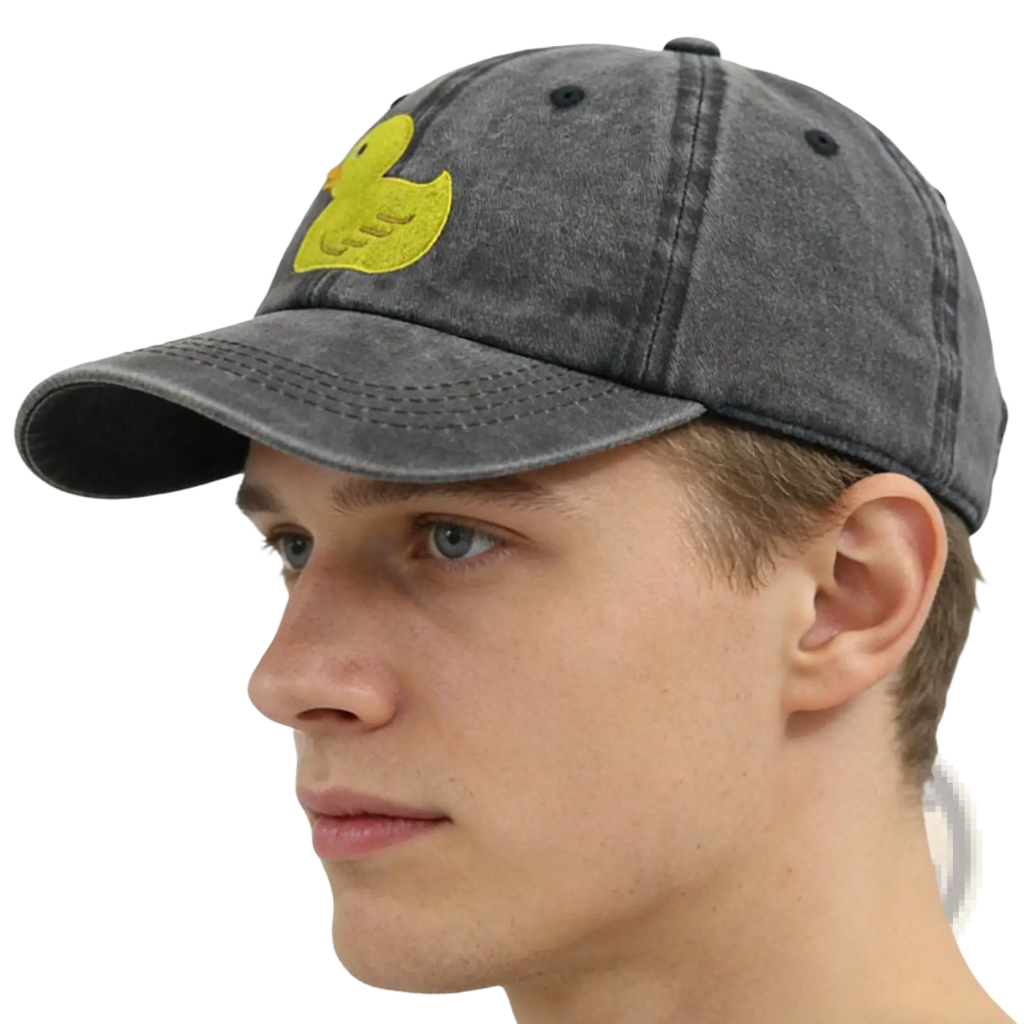 A faded gray distressed denim baseball cap with a bright yellow embroidered duck on the front