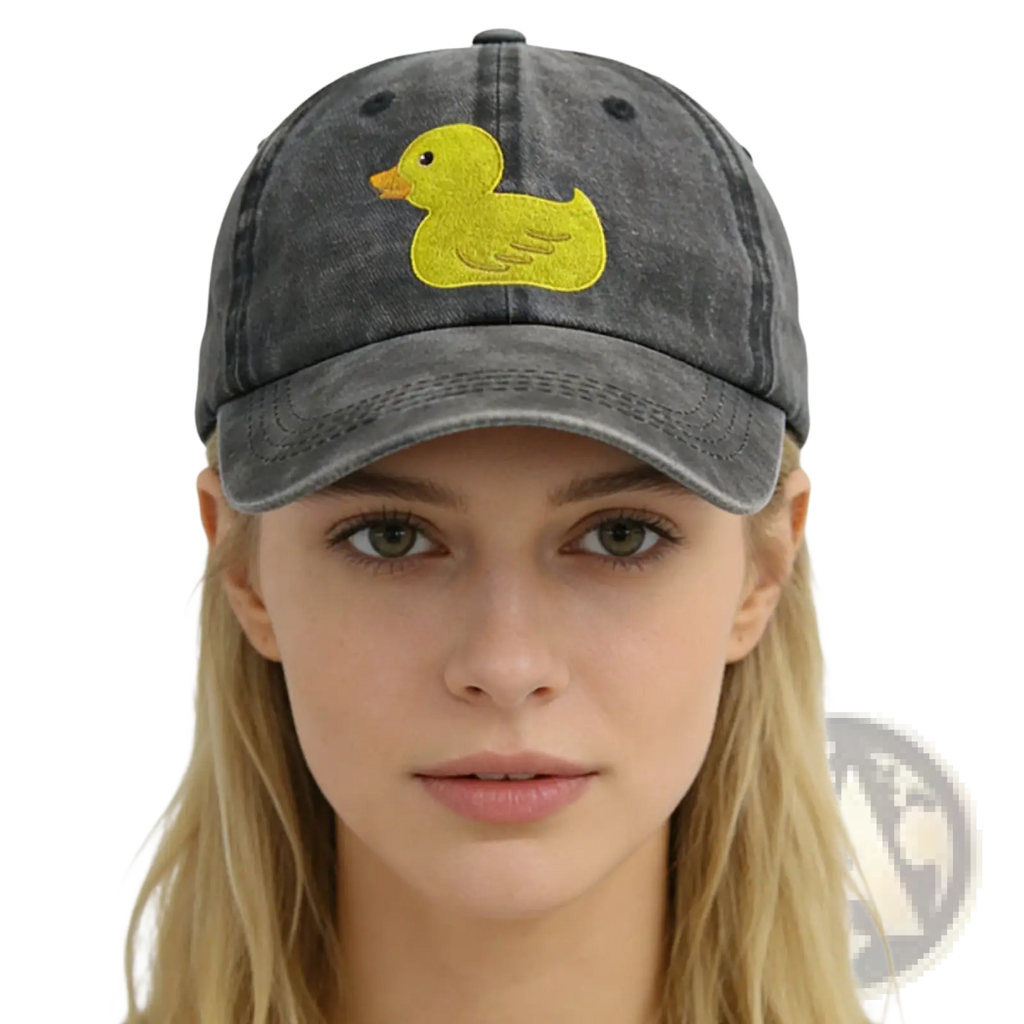 A faded gray distressed denim baseball cap featuring a bright yellow embroidered duck on the front