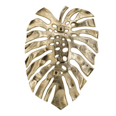 Gold-toned metal monstera leaf wall decor with a textured hammered finish and cut-out patterns for decorative use and serving tray functionality.