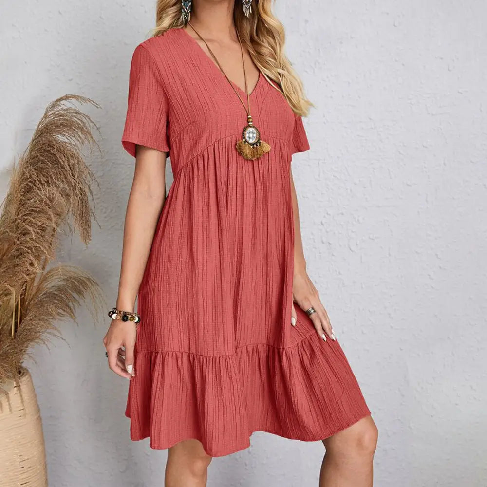 Une robe d’été en coton plissé pour femmes, d’une teinte châtain clair, à encolure en V et à volants superposés.