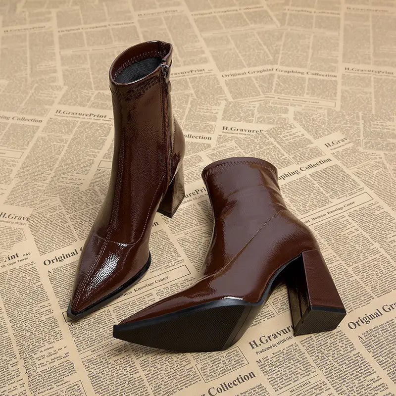 Burgunderfarbene Stiefeletten aus Lackleder mit spitzem Vorderteil und Blockabsatz, dargestellt von der Rückseite.