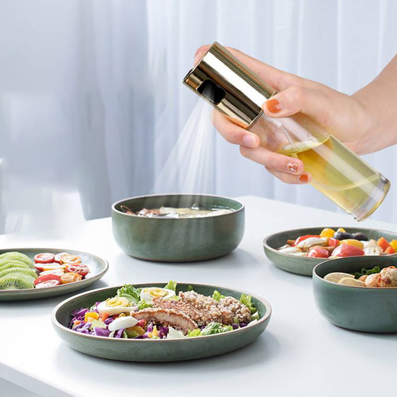 Goldfarbene Sprühdüse auf einer klaren Glas-Ölsprühflasche, entworfen als auslaufsicherer Kochsprayer.