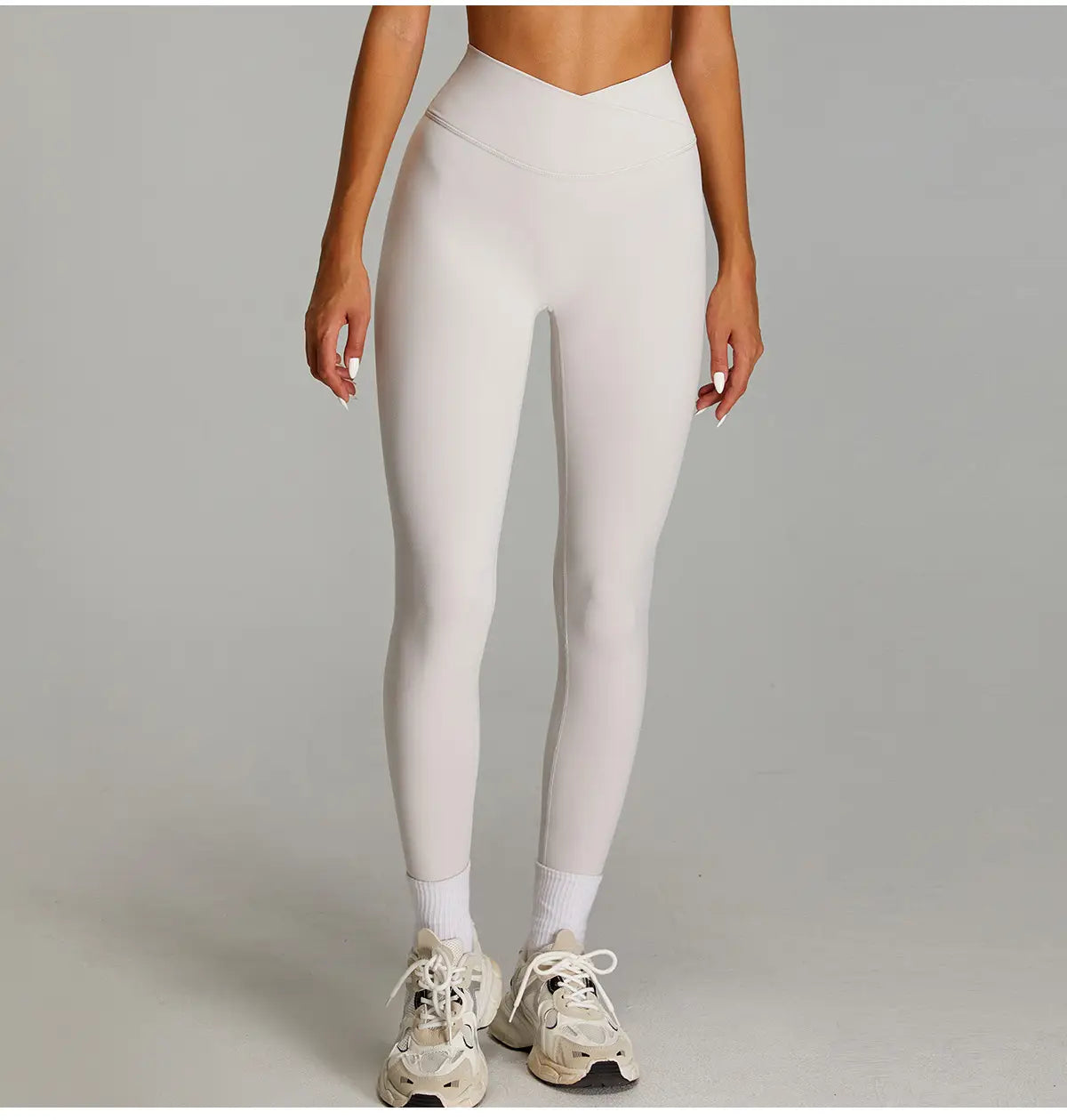 Pantalons de fitness crème à taille haute, au design élégant et ajusté, réalisés dans un matériau à séchage rapide pour le sport et les vêtements actifs.