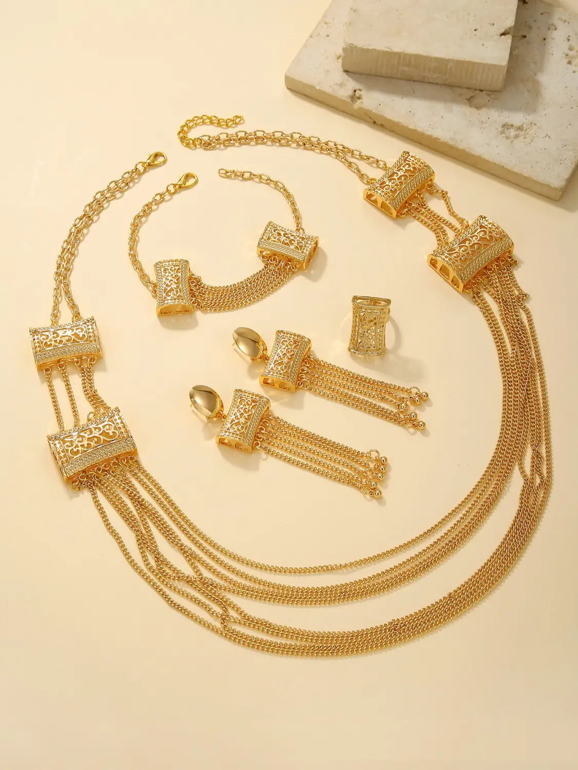 Gold layered tassel necklace and jewelry set featuring gold-toned metal with intricate filigree detailing and cascading chain strands.