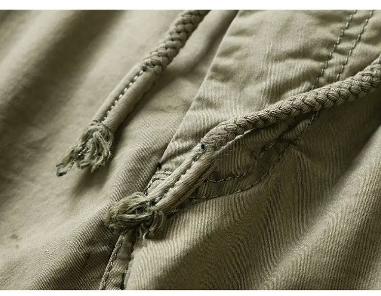 Beige cotton cargo shorts with a relaxed fit featuring a canvas drawstring with frayed ends and braided texture.