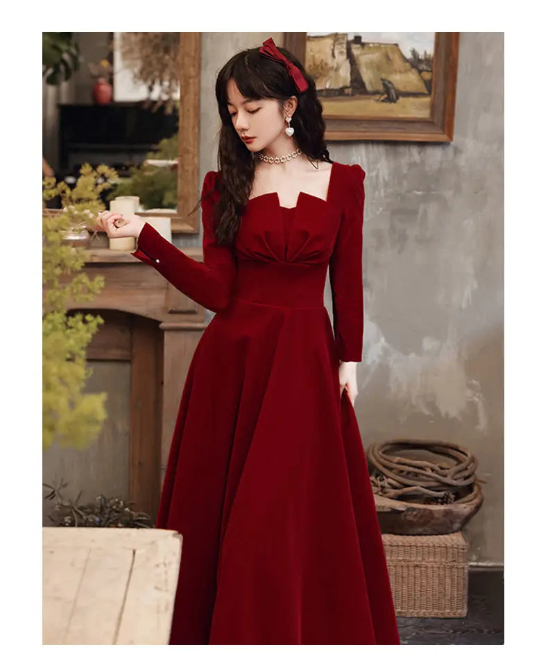 A rich burgundy velvet long sleeve A-line gown featuring a square neckline.