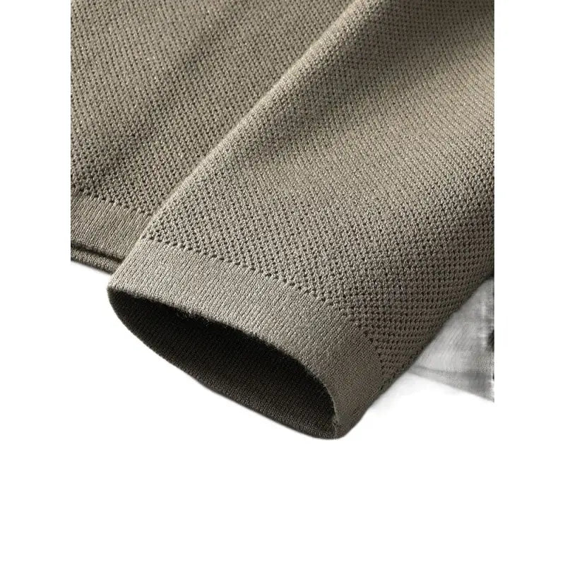 A close-up of a soft olive green slim fit knit cardigan sweater featuring a textured pattern and ribbed cuff.
