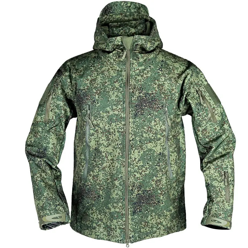 Veste tactique softshell à capuche en vert, camouflage numérique, avec plusieurs poches zippées et des poignets renforcés.