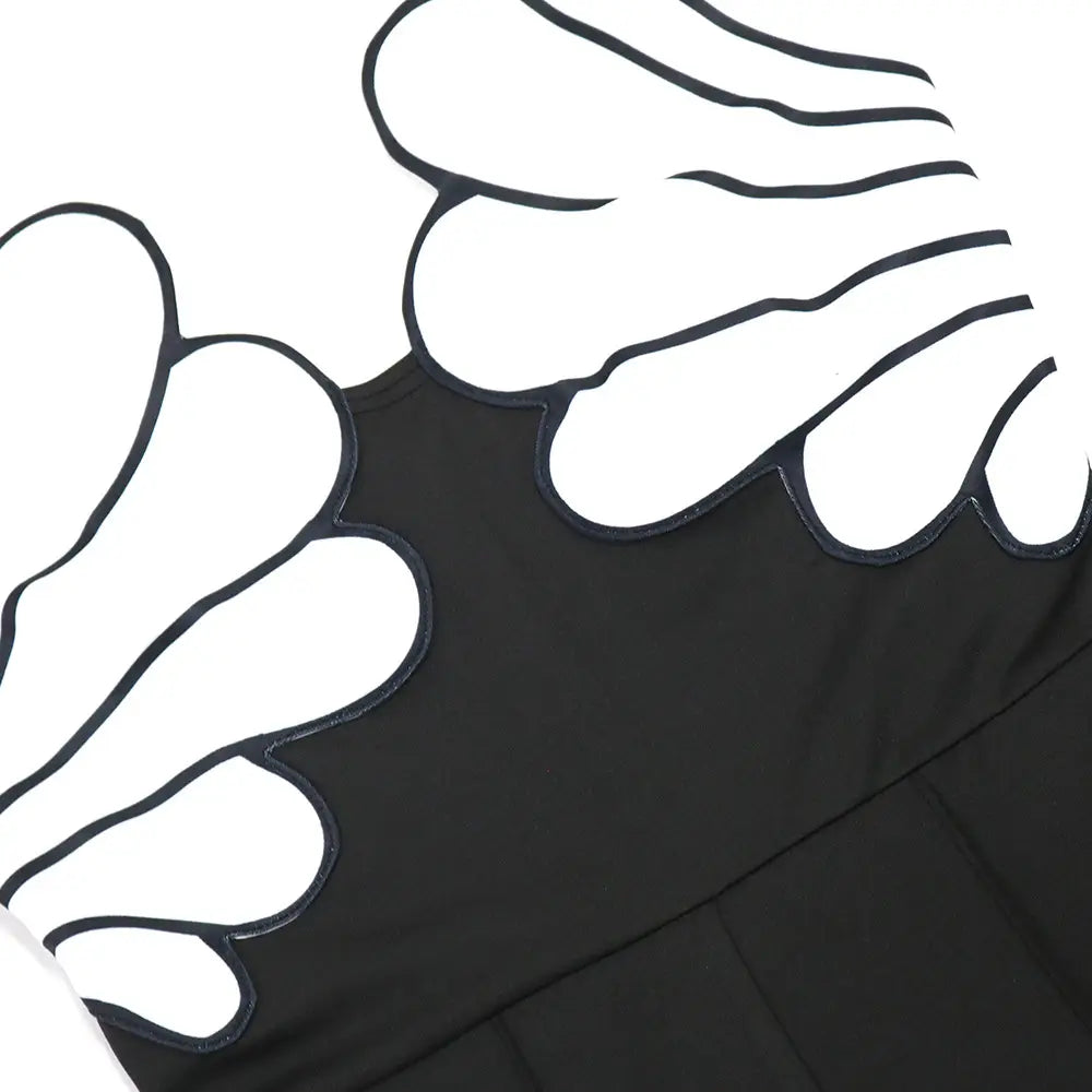 black fabric butterfly wing slim fit jumpsuit featuring bold white wing appliqués outlined in black stitching visible on the back side