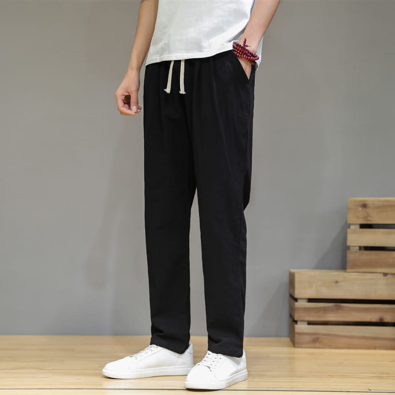 Herren-Slim-Fit-Jogginghosen aus schwarzem Baumwoll-Leinen mit weißer Baumwollkordel und seitlichen Taschen.