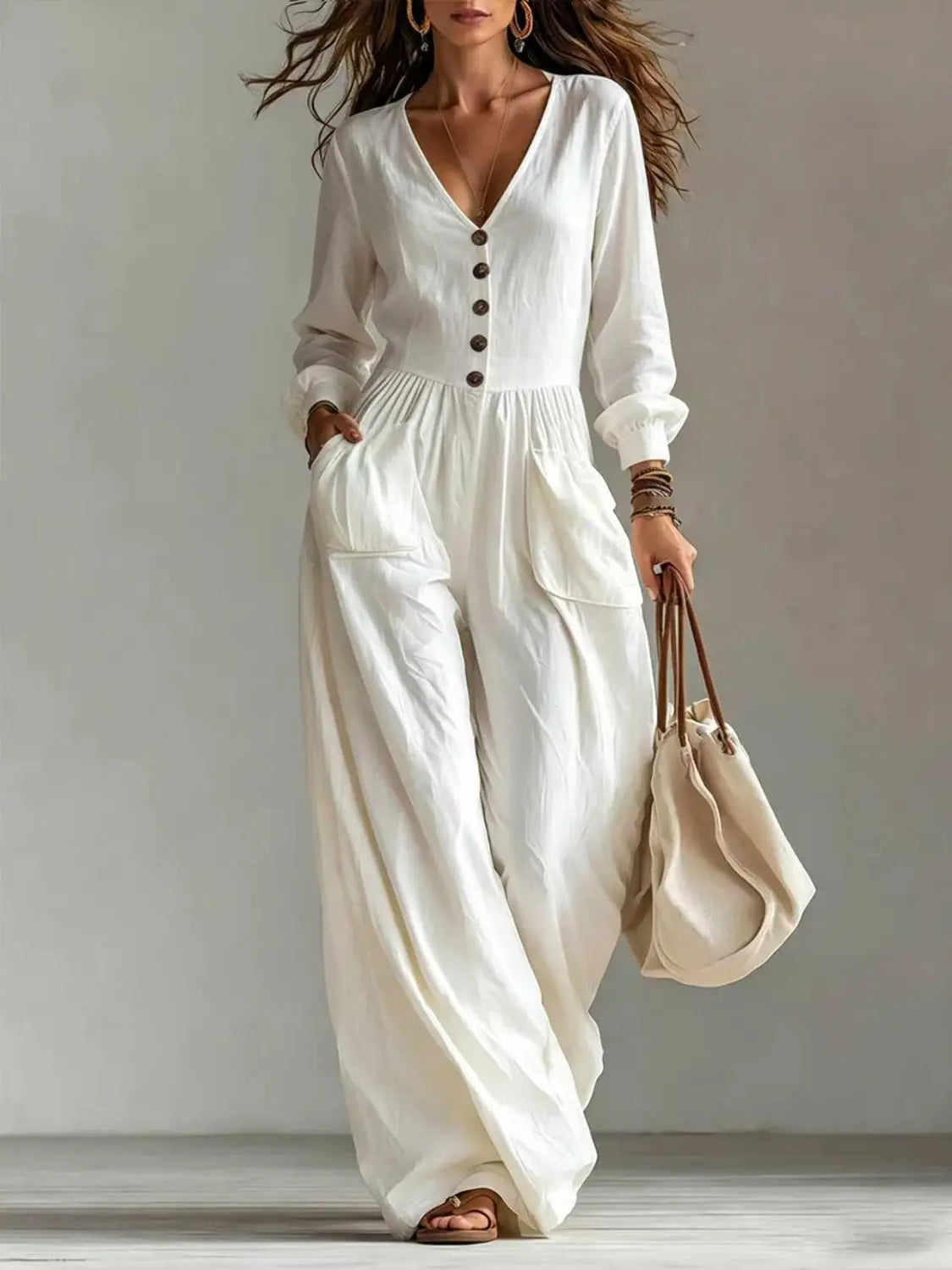 Une combinaison ample à jambes larges pour femmes en lin blanc, décolleté en V, manches longues, avec détails à l’avant boutonné et coupe décontractée.