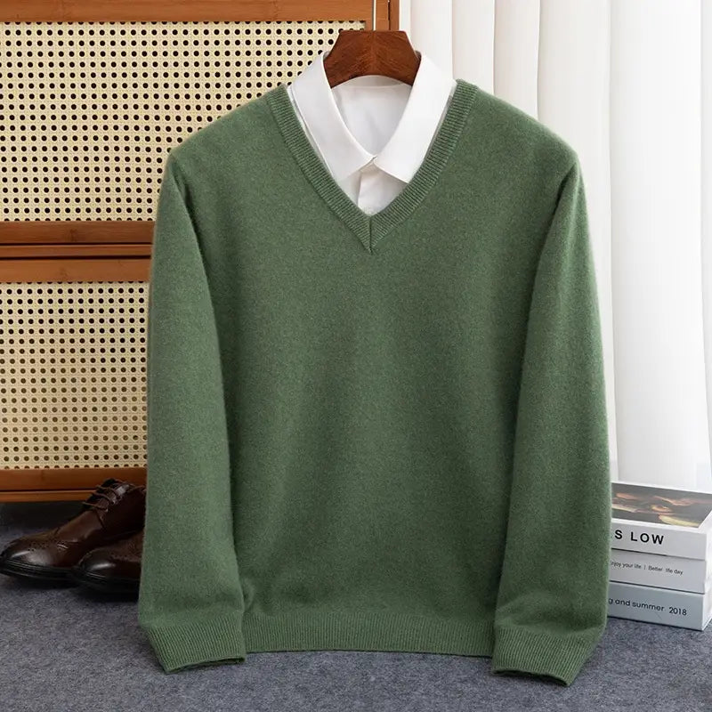 Ein weicher olivgrüner Wollstrickpullover für Herren mit V-Ausschnitt, geripptem Strickkragen und Bündchen, getragen über einem weißen Hemdkragenhemd, geeignet für die Wintersaison.